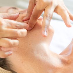Massage Kobido du visage à Cesson-Sévigné, mains de la praticienne travaillant en douceur sur le front de la cliente.